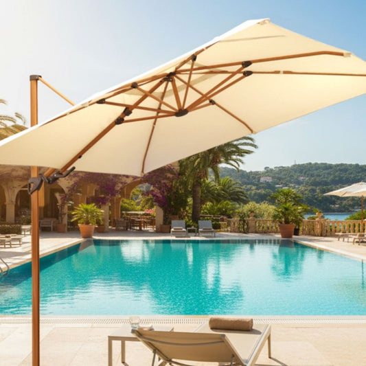 Ombrelone Manorca de madeira e tecido bege em área de piscina luxuosa de resort, com espreguiçadeira em primeiro plano.