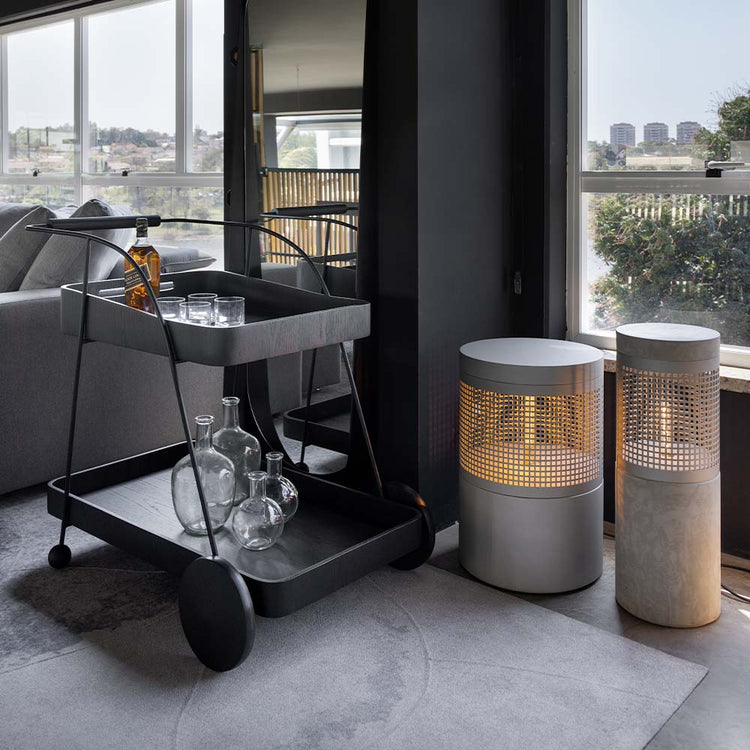 carrinho bar com estrutura em metal preto e bandejas de apoio em madeira pintada num ambiente minimalista e sofisticado