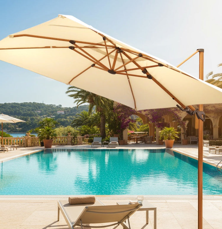 ombrelone fazendo sombra em uma espreguiçadeira, possui estrutura em alumínio em pintura simulando madeira natualra com tecido bege a beira de uma piscina retangular linda