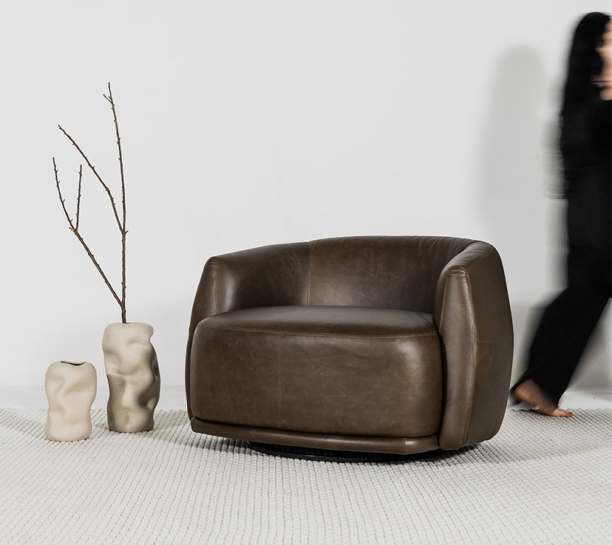 poltrona giratória em couro marrom demonstrando conforto em um ambiente clean e minimalista