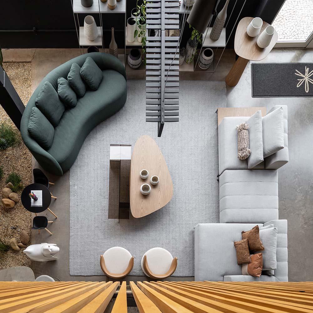 foto de um ambiente de alto padrão com angulo superior, mostrando poltronas, sofás, cadeiras, mesas de centro e objetos decorativos.