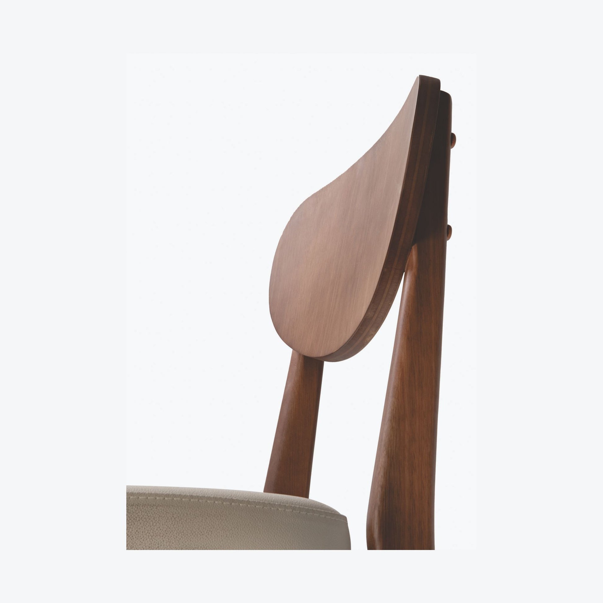 Detalhe do encosto curvo da Cadeira Dakota em acabamento nogueira.