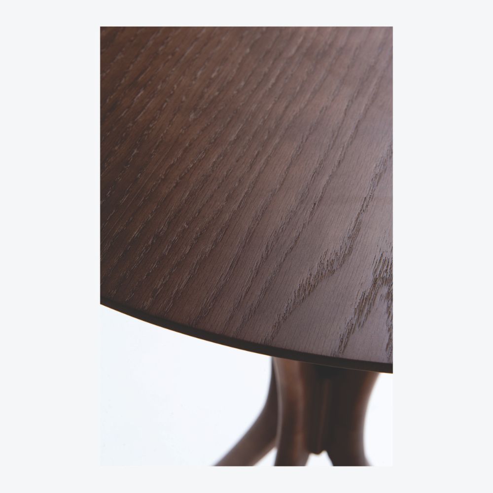 Detalhe de perto do tampo da Mesa bistrô Montana em madeira tingida, exibida sobre fundo branco.