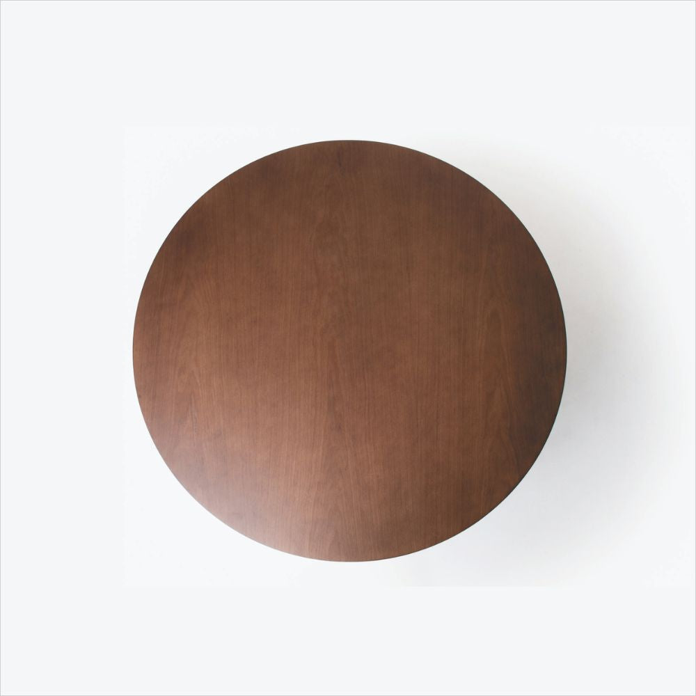 Vista superior da Mesa de Jantar Kansas detalhando o tampo redondo em madeira tingida ao fundo branco.
